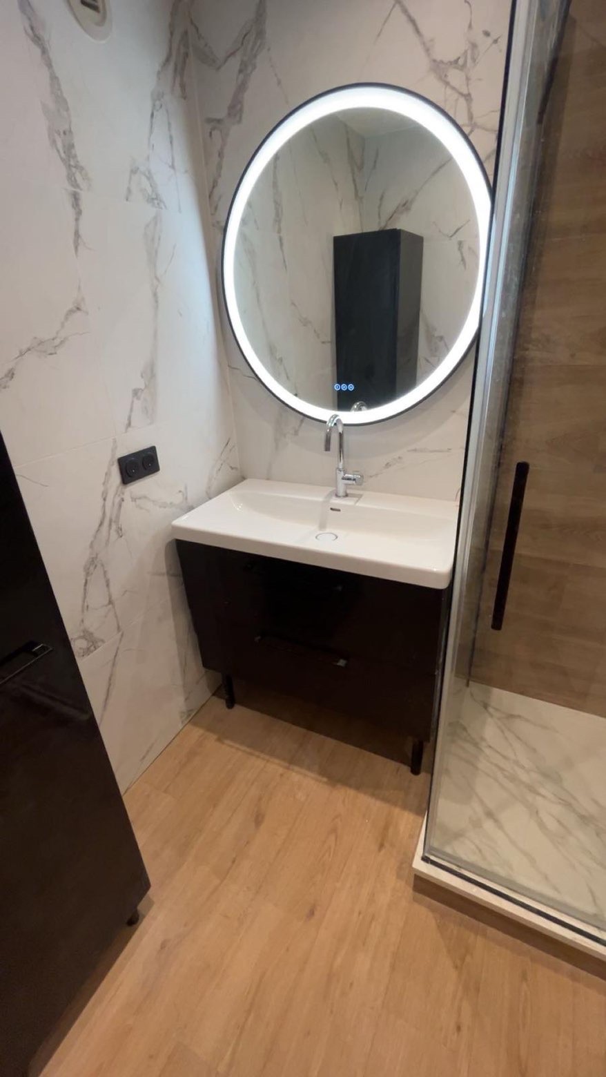 Salle de bain moderne avec miroir LED et meuble vasque noir - Plombier Île-de-France