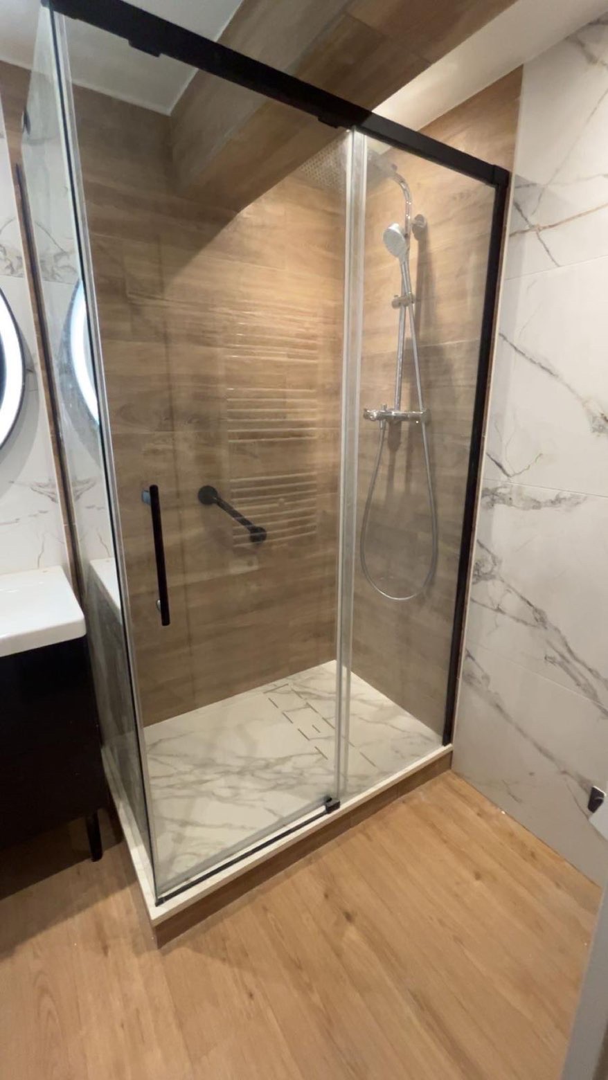 Cabine de douche moderne avec carrelage bois et marbre - Plombier Île-de-France